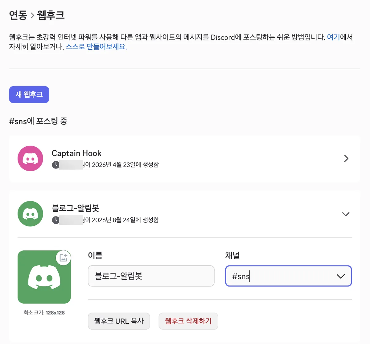 A newly created webhook expanded. It shows the name Blog-Alert-Bot and the sns channel selected. On the left is an avatar upload box with a minimum size of 128x128. Below are a gray Copy Webhook URL button and a red Delete Webhook button, side by side.