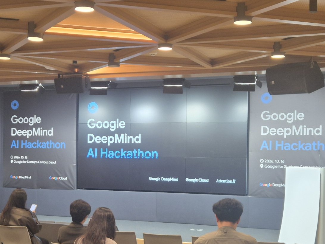 Stage and audience with a Google DeepMind AI Hackathon banner